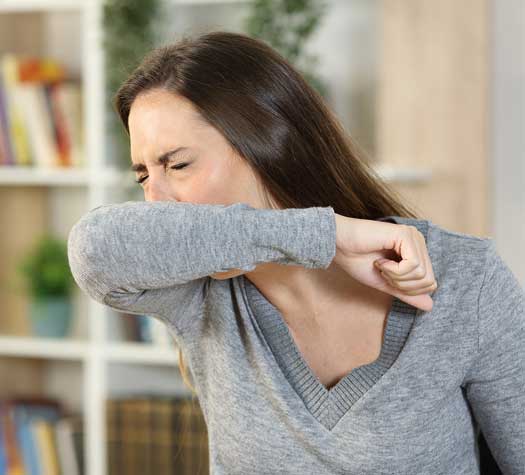 Woman sneezing from allergies from poor indoor air quality